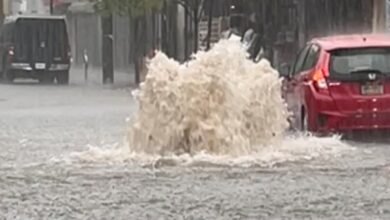 Photo: A car drives in a flooded street after strong downpours in Staten Island, New York