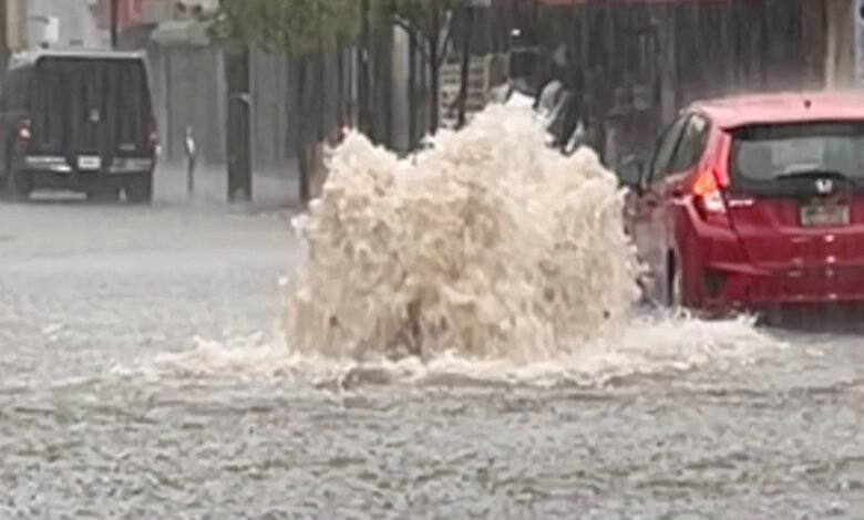 Photo: A car drives in a flooded street after strong downpours in Staten Island, New York