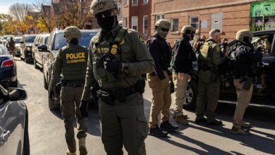 PHOTO: Federal agents confront community members during immigration raids